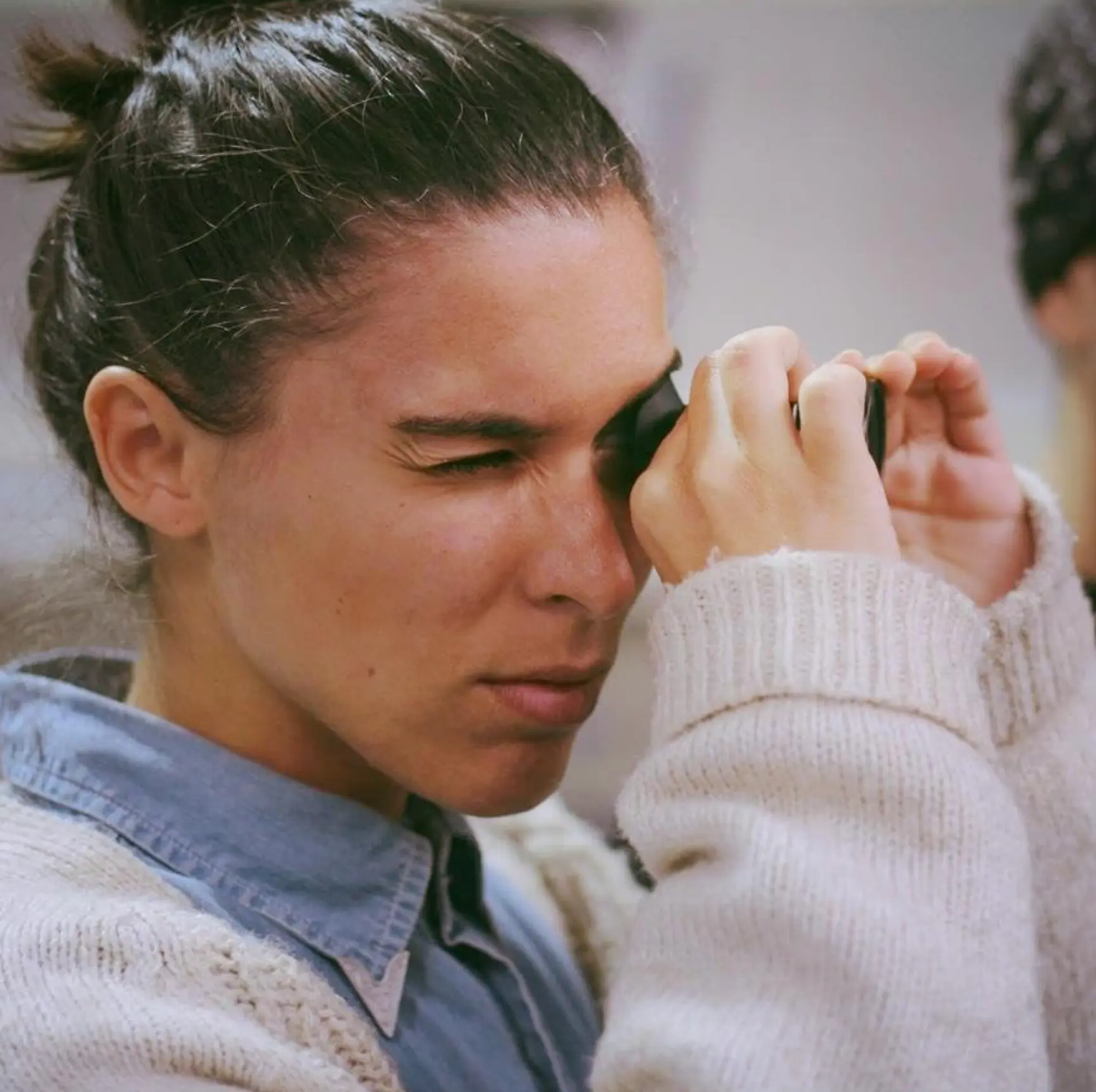 Teresa Correia looking through a camera viewfinder